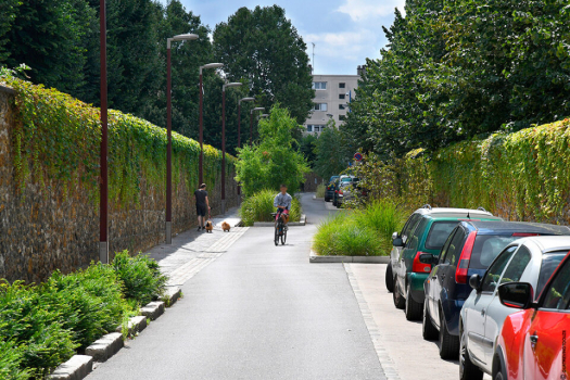 La chaussée a un profil en toit et les eaux pluviales sont dirigées dans les fosses de plantations où elles peuvent entrer grâce à des passages d’eau créés dans les bordures. Aménagement finalisé, rue Soeur Valérie, Asnières-sur-Seine (92)